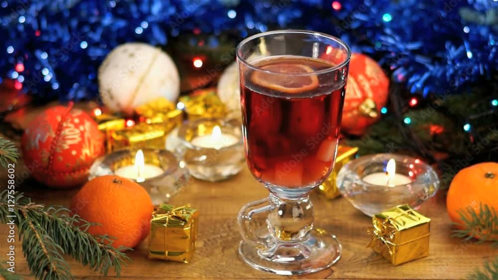 two sugar cubes falling into glass cup of black tea with lemon on the christmas table two sugar cubes falling into glass cup of black tea with lemon on the christmas table