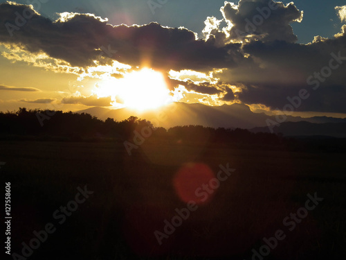 Sunset in mountains, behind a cornfield. photo