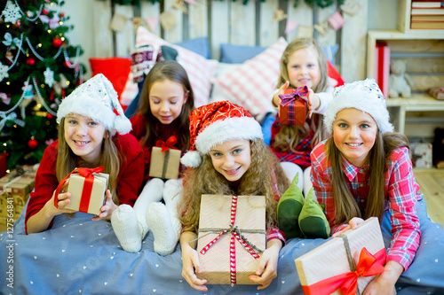 Group of kids in red hat with Christmas gifts