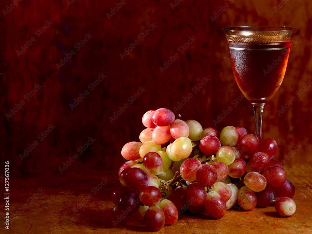 bunch of red grape and wine glass