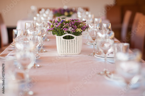    table setting in restaurant with flowers and wineglasses