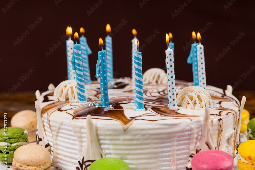 Close up of homemade birthday cake with lots of burning candles