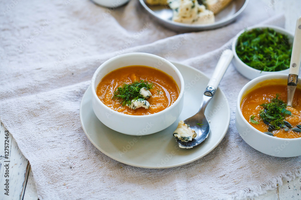 Butternut squash soup in bowls. Sweet potato creamy soup with fresh herbs. Butternut squash soup in bowls. Sweet potato creamy soup with fresh herbs.