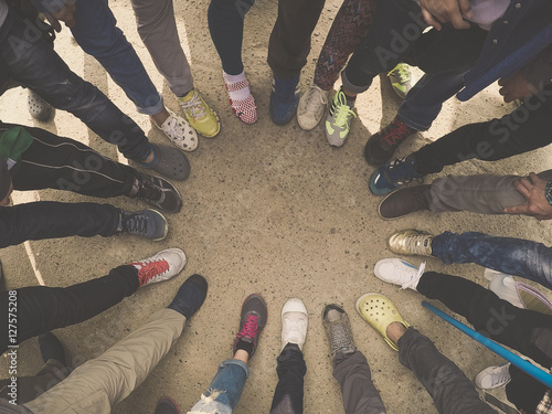 Top view of feet of people standing in a circle. Runners standing in a huddle with their feet together. photo