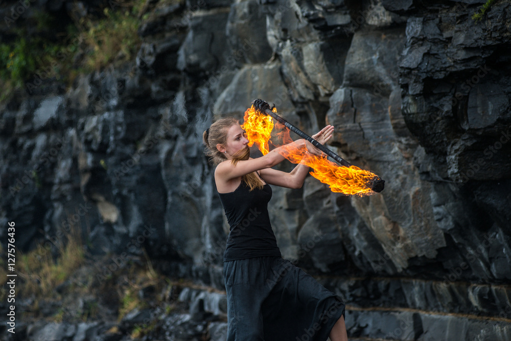 Girl in a black suit with flaming torches . Girl in a black suit with flaming torches .