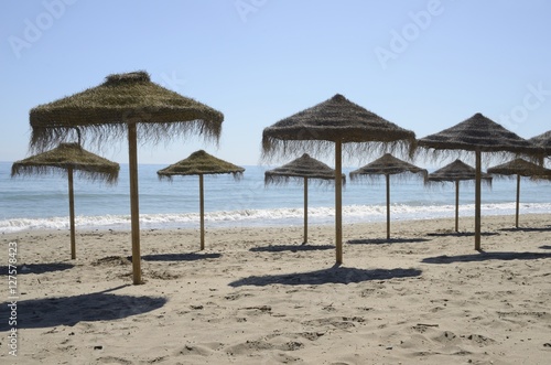 Row of straw umbrellas in Marbella  Spain
