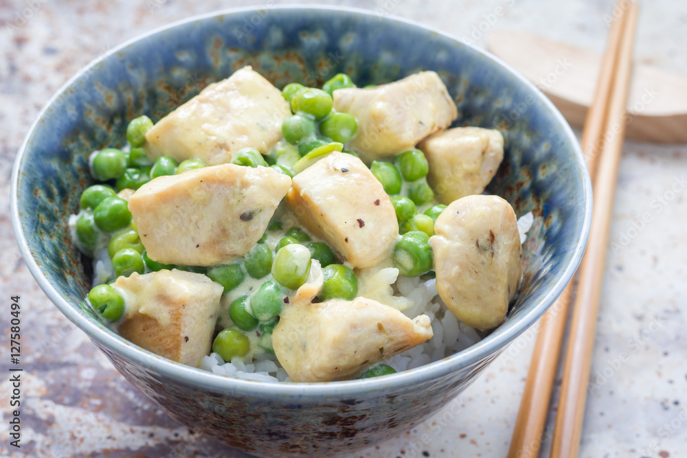 Fried chicken with green peas in cream sauce, served with rice, horizontal, closeup