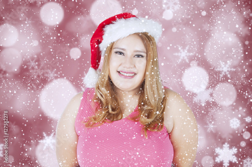 Happy fat woman wearing santa hat