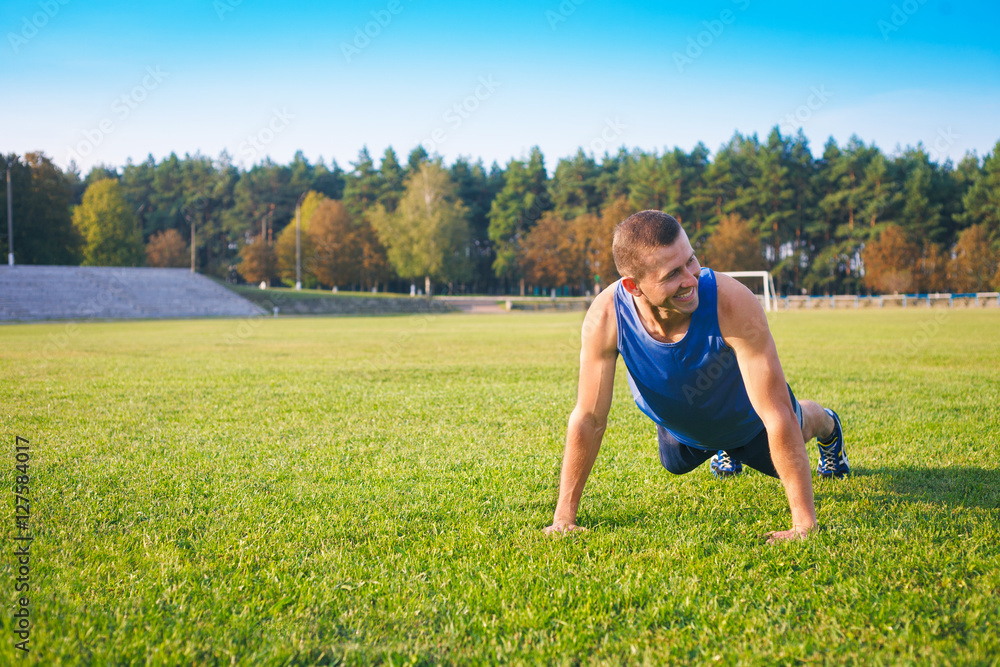 Fitness man doing push-ups on the grass. Fitness man doing push-ups on the grass.