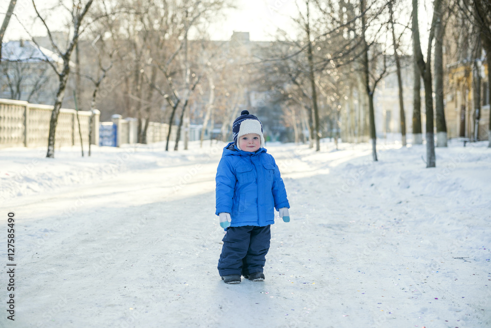 winter dressed boy walking on a snowy street