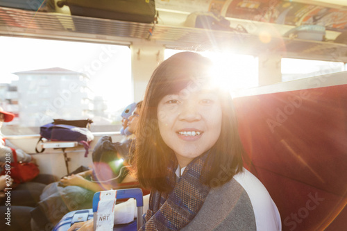 Young asian woman traveling looking out the window. photo