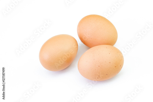 Three brown raw eggs isolated on white background