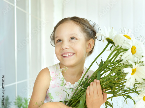 Little girl with dasies flowers photo