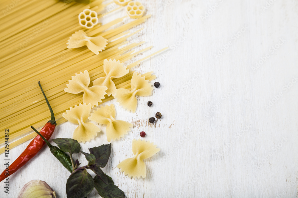 Raw pasta and spices in wooden table. Pasta and ingredients: chi Raw pasta and spices in wooden table. Pasta and ingredients: chi