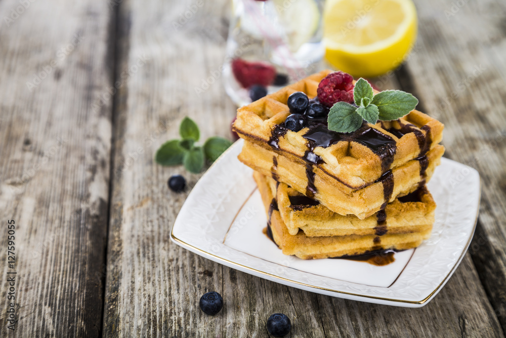 Belgian waffles with raspberries, blueberries and mint, covered Belgian waffles with raspberries, blueberries and mint, covered