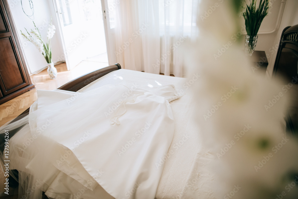 White Wedding dress on a bed, before ceremony White Wedding dress on a bed, before ceremony