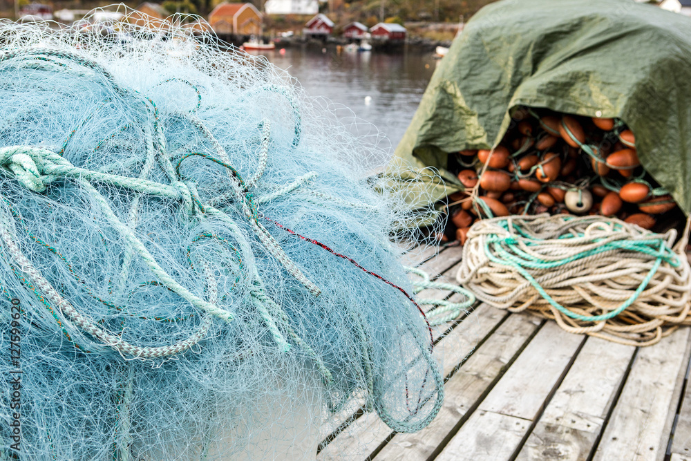 Many fishing nets and floats, stacked on a wooden dock. Fisheries, fishing.  Fishing industry. Background. Stock Photo