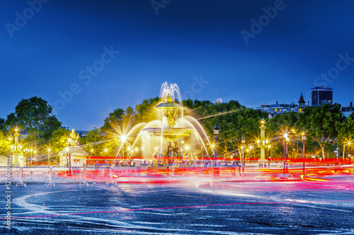 Fountain at the Place de la Concorde in Paris by night, France. Night scene. Traffic tracers from cars at long exposure.