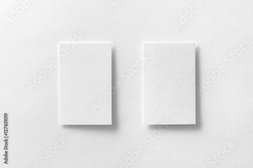 Mockup of two vertical business cards at white textured paper