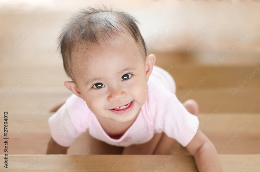 Beautiful smiling asian baby girl while crawling up a stair. Beautiful smiling asian baby girl while crawling up a stair.