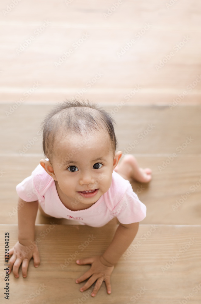 Beautiful smiling asian baby girl while crawling up a stair. Beautiful smiling asian baby girl while crawling up a stair.