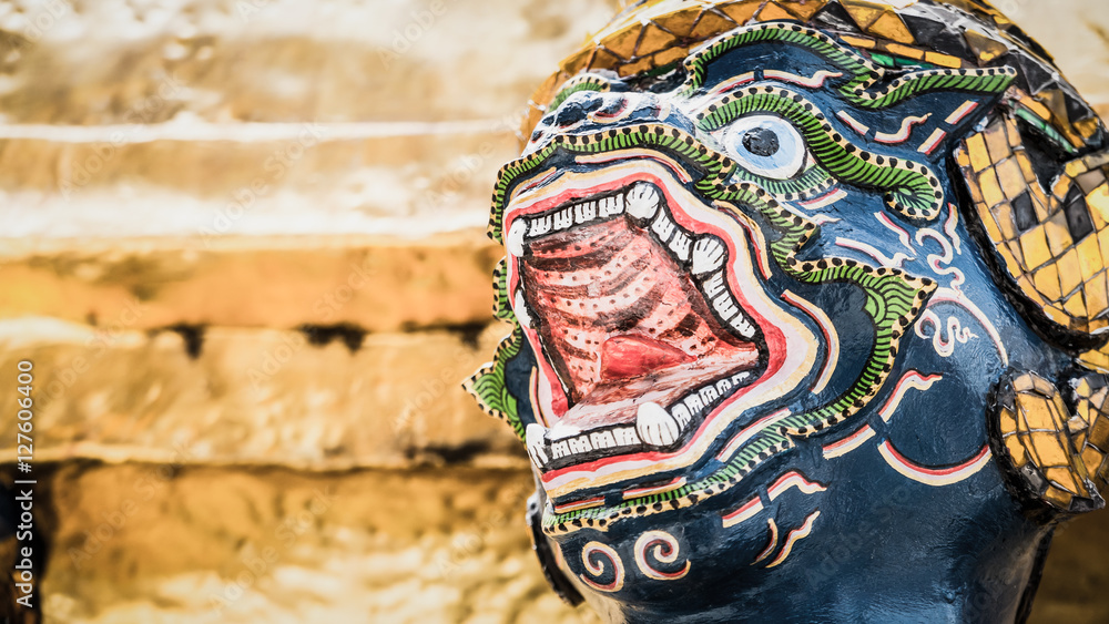 The face beautiful of golden monkey statue under golden pagoda in Thailand of the Emerald Buddha temple(Wat phra kaew) and Royal Grand Palace ,Bangkok,Thailand