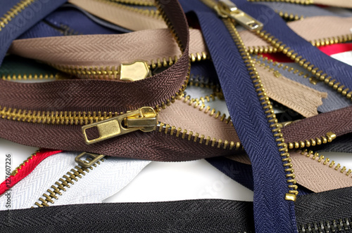 Metallic jeans zippers on white background