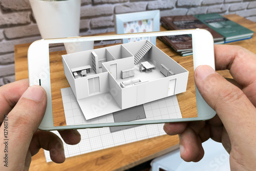 Augmented reality marketing concept for architecture. Hand holding smart phone using AR application to simulate 3d popup interactive room maps to life. 3d rendering photo