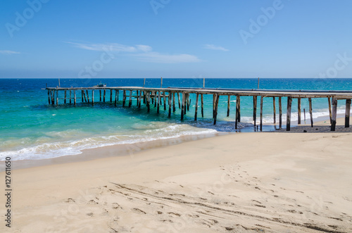Long simple wooden jetty leading into turquoise blue ocean in Angola © Fabian