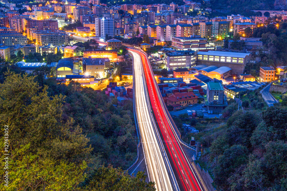 View on highway in the west part of Genoa by night, Italy, a view of industrial and residential area.