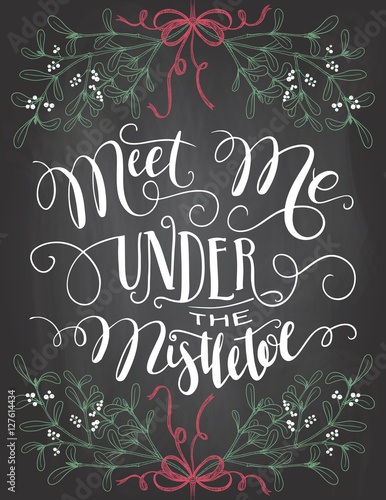Meet me under the mistletoe. Brush calligraphy on blackboard background with chalk. Christmas chalkboard typography