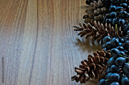 Grapes and pine cones on a wooden table
