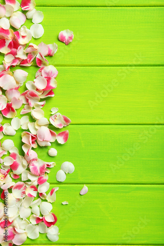 Rose petals on green wooden table