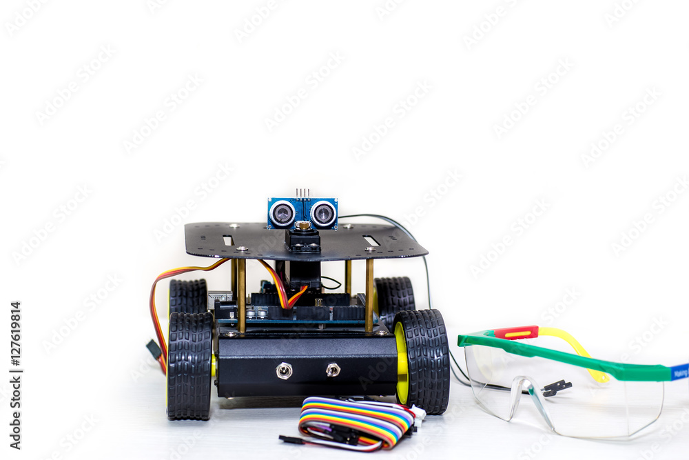metal robot on wheels with the eyes and wires, as well as with the glasses on a white background