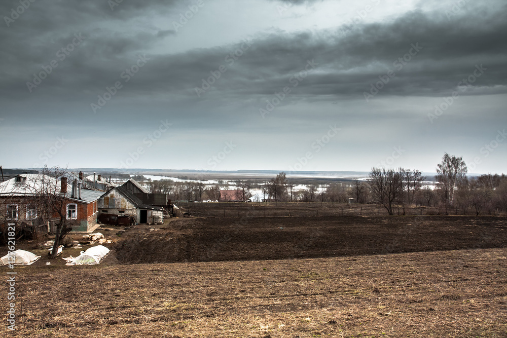 Dramatic agricultural countryside landscape with moody sky and cultivated field of farmer's plantation