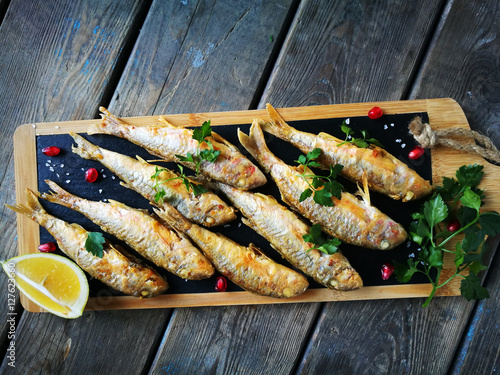 fried goatfish surmullet with lemon on board photo