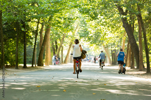 Photography Women bikes through a sunny Vondelpark.