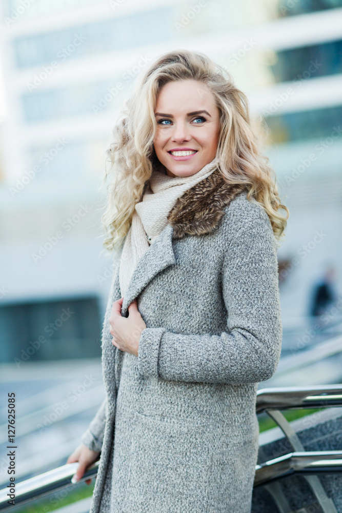 Beautiful woman in stylish autumn clothes posing on urban background Beautiful woman in stylish autumn clothes posing on urban background
