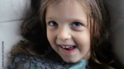 little girl three years old in a green dress smiling