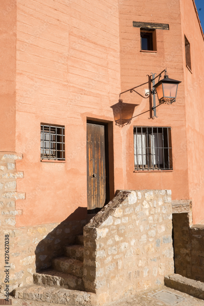 Casa junto a una escalera  en un pueblo antiguo español con un farol 