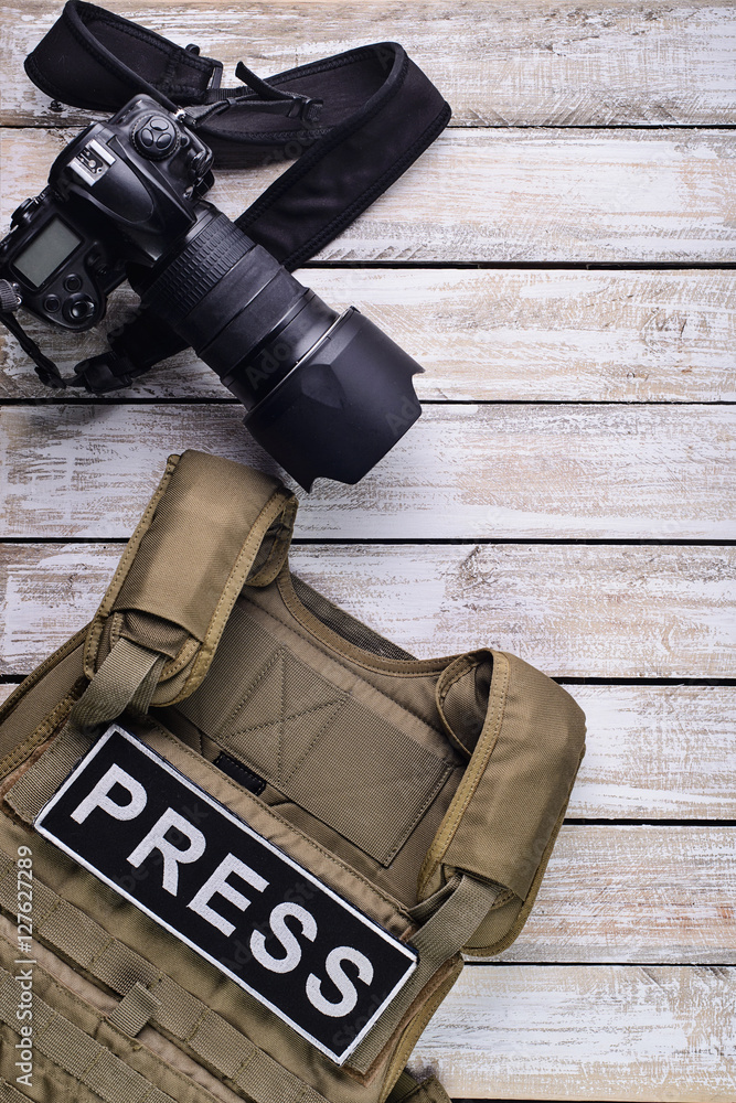 Digital camera and bulletproof vest/Body armor with patch "PRESS" and DSLR  camera on wooden table top view. Stock-Foto | Adobe Stock