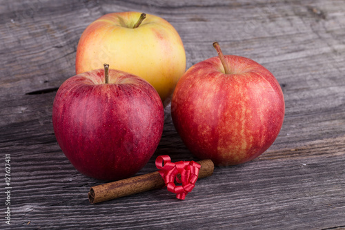 Apples with cinnamon on wooden background