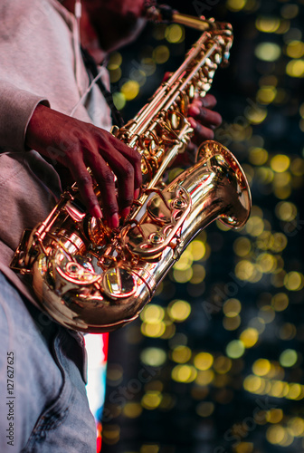 Canvas Print Saxophonist playing in the street with christmas lights