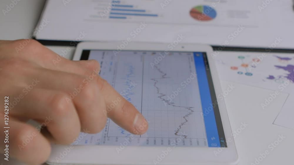 Businessman checking stock market at his tablet Businessman checking stock market at his tablet