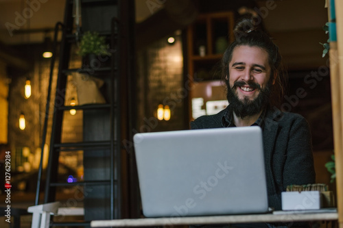 Smiling Caucasian man rewriting in social network with his frien