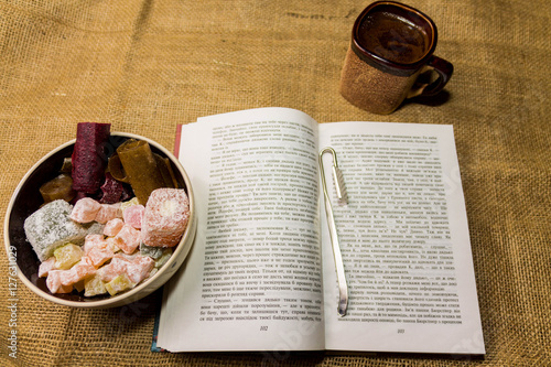 Cup of coffee with sweets and a book.