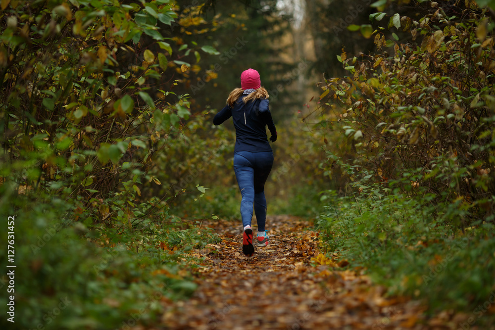 Blonde woman running on trail Blonde woman running on trail