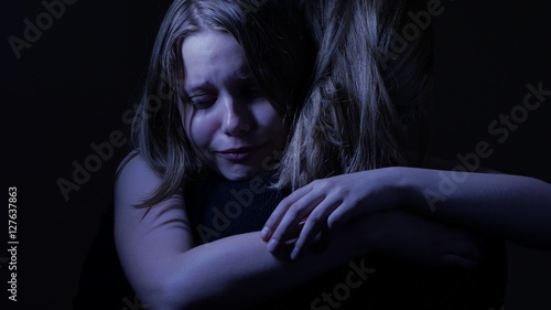Sad teenager daughet and her loving mother.