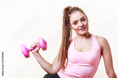Sporty girl lifting weights.