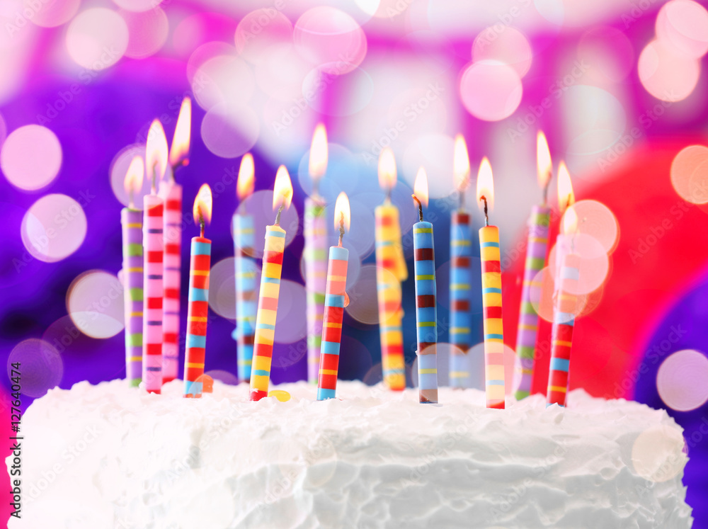 Lighted candles on birthday cake, closeup Lighted candles on birthday cake, closeup